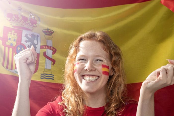 smiley-frau-die-die-spanische-flagge-haelt-1-_freepik.jpg