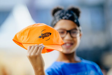 Mädchen hält Kappe mit dem Logo der Expedition Wissenschaft in die Kamera
