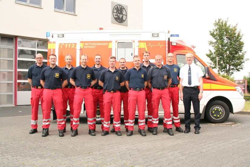 Gruppenbild der ersten Notfallsanitäter mit Ralf Schmitz vor einem RTW