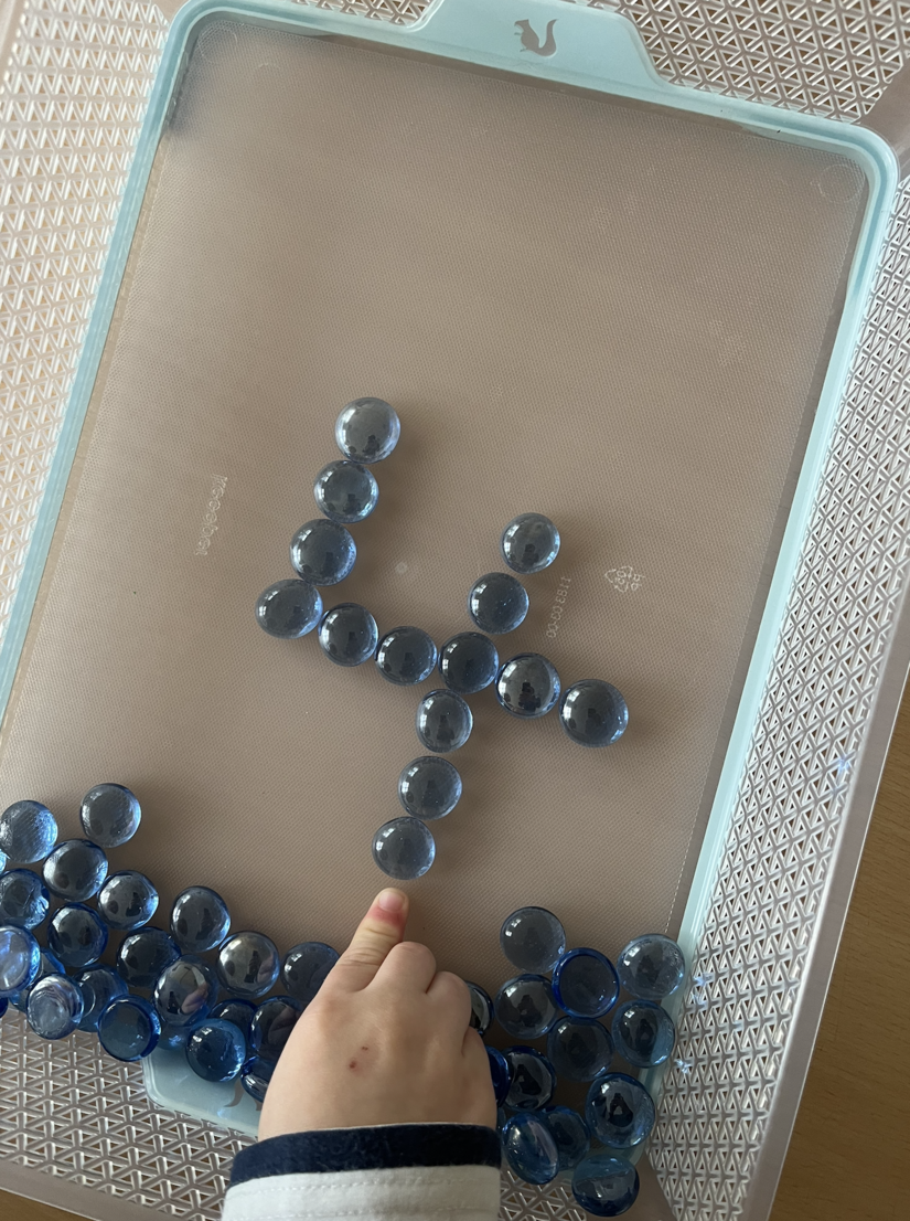 Die Ziffer 4 mit Muggelsteinen ausgelegt.