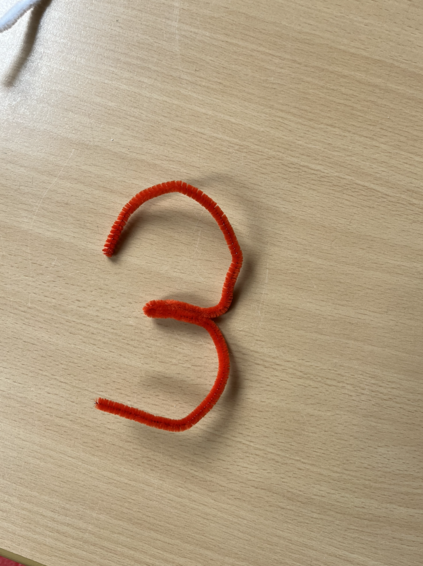 Die Ziffer 3 mit Pfeifenputzer ausgelegt.