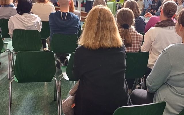 Frau Schäfers hält eine Rede, die anderen Menschen sind von hinten zu sehen.