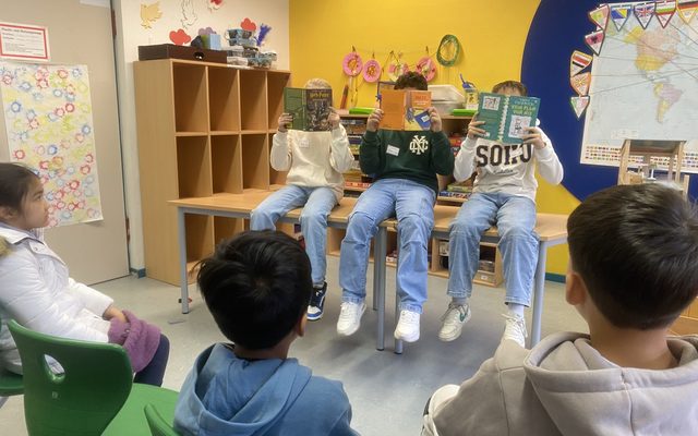 Die Vorleserkinder des Goerdeler Gymnasiums (ihr Gesicht ist von einem Buch verdeckt)
