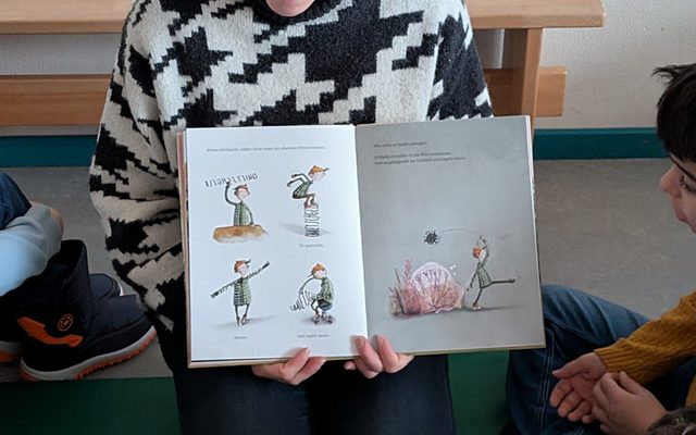 Eine Lehrerin des GSV liest den Kindern vor.