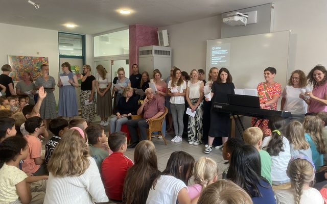 Die Lehrkräfte sind aufgestellt um ein Lied zu singen.