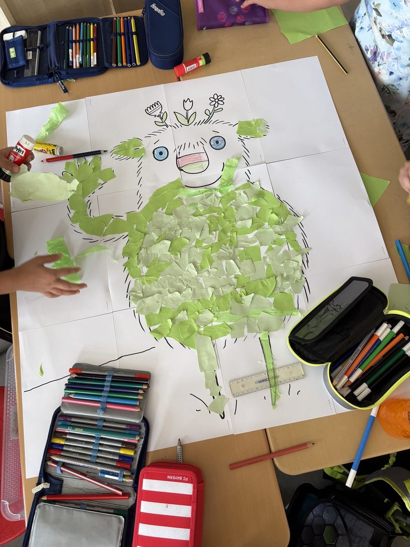 DAs kleine Wir ist in Großformat zu erkennen und wir mit grünen Schnipseln beklebt.