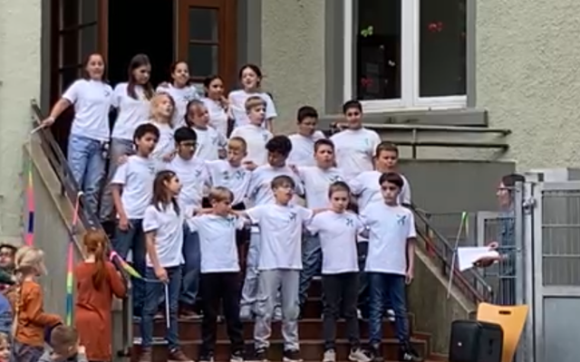 Die Viertklässler des Teilstandortes stehen vor dem Haupteingang und halten sich in den Armen.