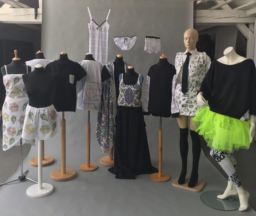 Kleiderpupen mit unterschiedlichen Kleidungsstücken vor einem grauen Hintergrund