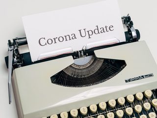 Ein Blatt in einer Schreibmaschine auf dem "Corona Update" steht.