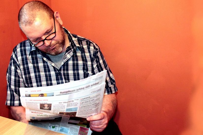 Mann mit Brille liest Zeitung