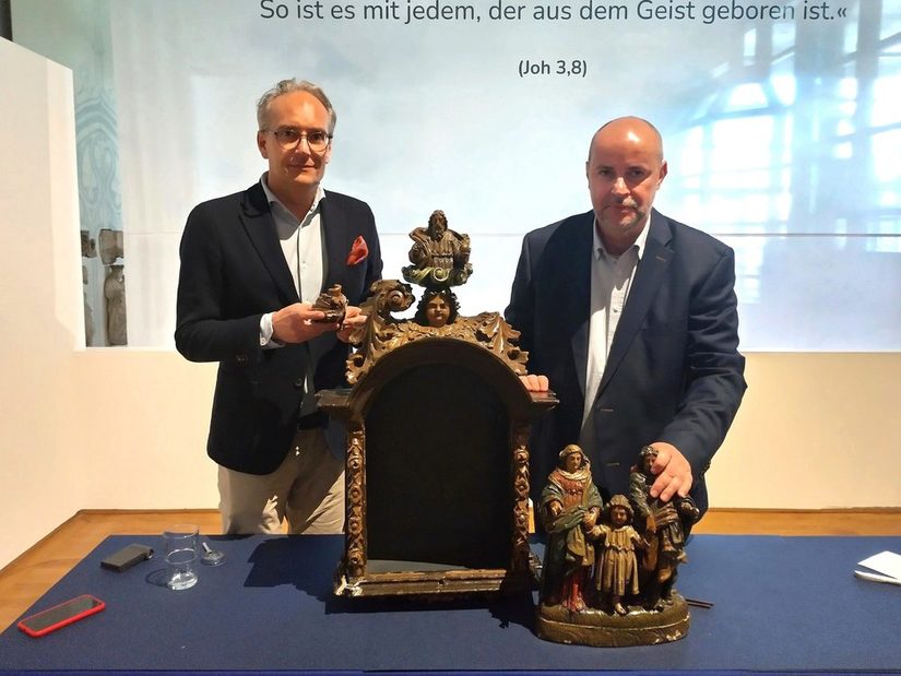Zwei Männer stehen vor Kunstwerken im Diözesanmuseum bzw. halten diese in der Hand