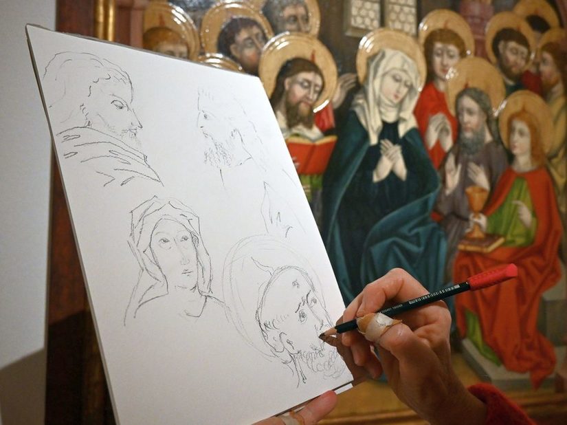 Mensch sitzt vor einem Bild und zeichnet es ab