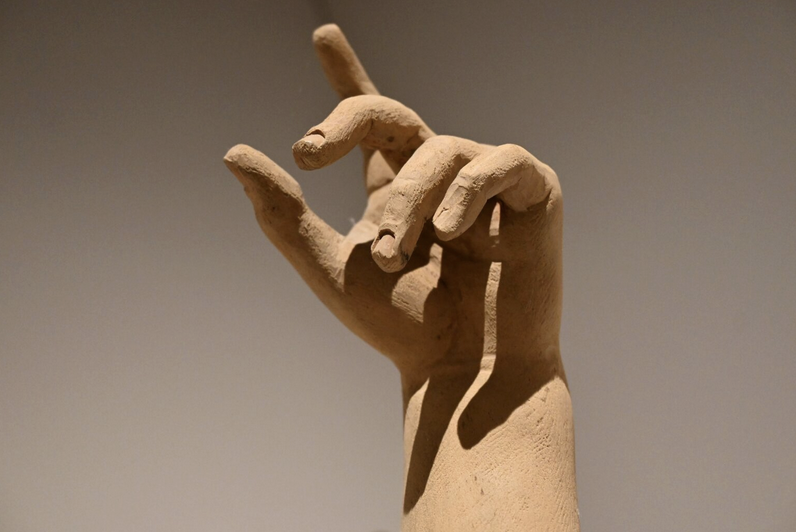 Die Hand einer Skulptur, die den Zeigefinger nach oben streckt