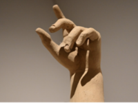Die Hand einer Skulptur, die den Zeigefinger nach oben streckt