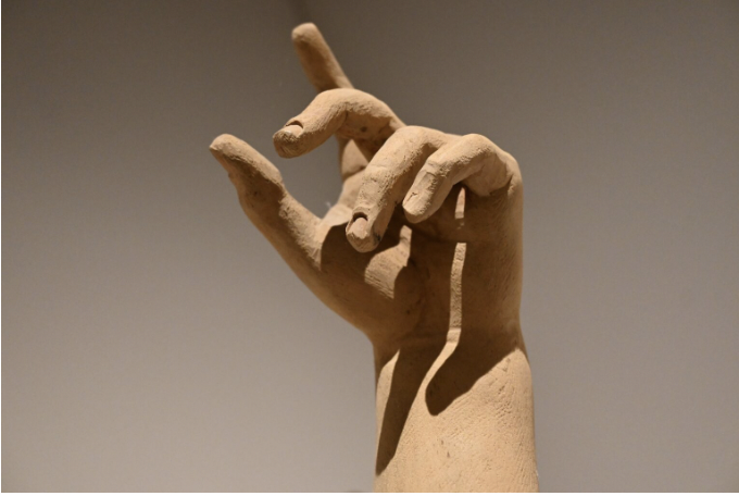 Die Hand einer Skulptur, die den Zeigefinger nach oben streckt