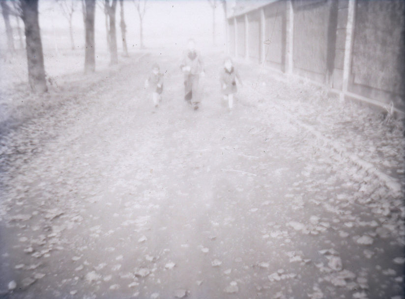 Ein schwarz-weiß Bild von laufenden, verschwommenen Kindern auf der Straße