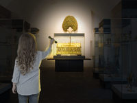 Ein Mädchen mit blonden Haaren hält die Taschenlampe auf den Schatz in der Schatzkammer des Diözesanmuseums Paderborn